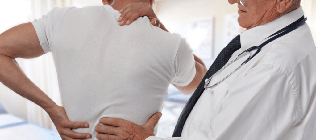 Especialista en columna valorando dolor lumbar y síntomas hacia la pierna
